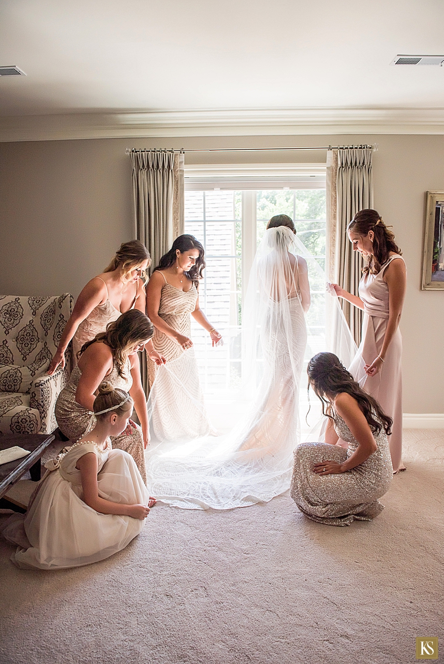 Bride by window with bridesmaids